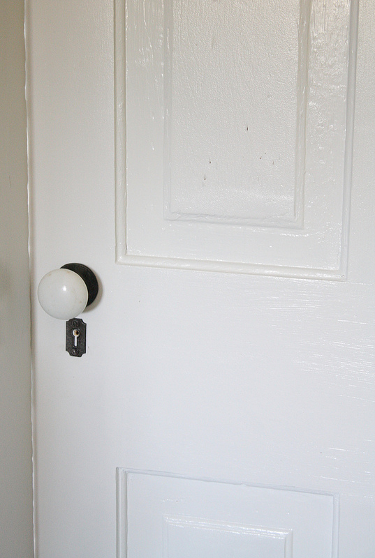 restored antique hardware, windows, White porcelain doorknobs are also original to this four panel door