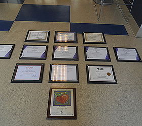 okay class here is a lesson in hanging a group of awards on the wall, home decor, Arrange the pictures on the floor then begin by hanging the center picture first and measure in this case 3 inches above below and on each side to hang the next and the next and so forth Bada Bing