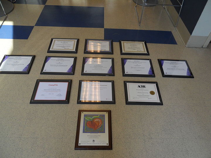 okay class here is a lesson in hanging a group of awards on the wall, home decor, Arrange the pictures on the floor then begin by hanging the center picture first and measure in this case 3 inches above below and on each side to hang the next and the next and so forth Bada Bing