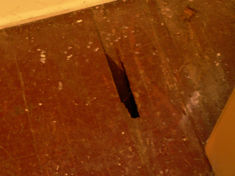 how to fix holes in these wood floors, another hole found under the carpet in the living room
