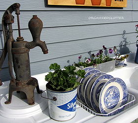 a whimsical outdoor kitchen, flowers, gardening, outdoor living, An old pump a vintage lard pail Blue Willow air drying in the sink and a vintage aluminum angel food pan fill the left side of the potting bench