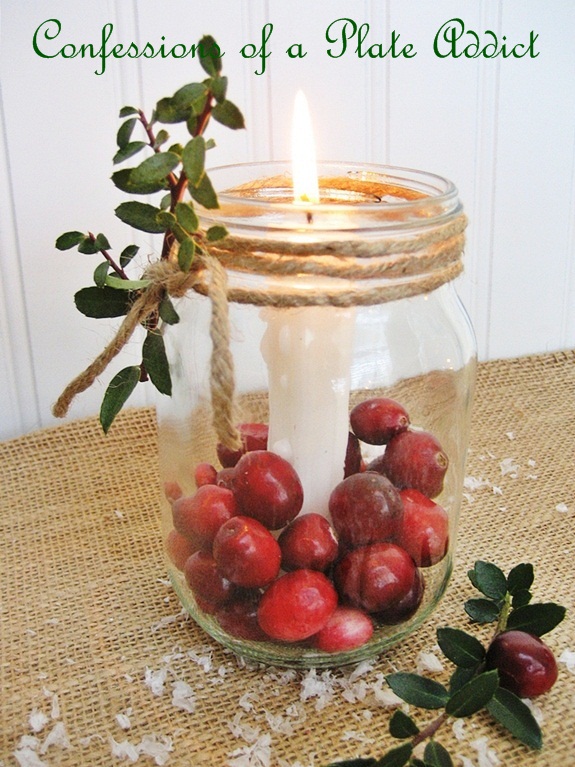 fun and easy christmas mason jar candles, christmas decorations, seasonal holiday decor, Just anchor a candle inside a Mason jar using candle wax or wax buttons Then add fresh cranberries and wrap jute twine around the rim Add a sprig of boxwood for a festive touch