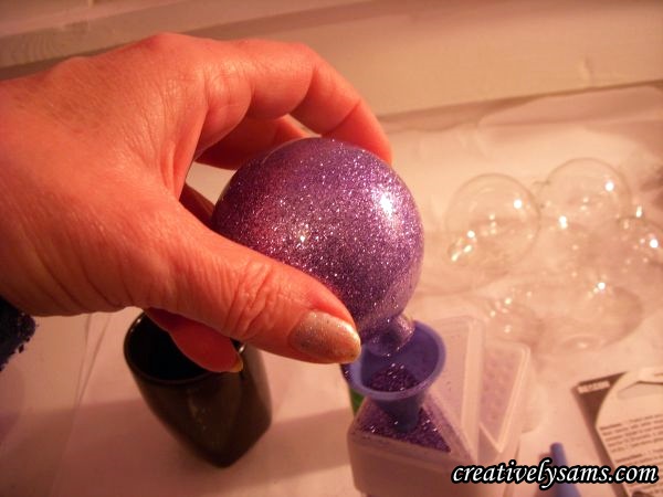 glitter ornaments, christmas decorations, seasonal holiday decor, Coat the inside of the ball with the glitter Pour out the excess glitter back into the glitter container