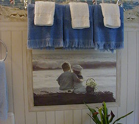 50s bathroom budget facelift, bathroom ideas, home decor, I wallpapered this poster to the wall and painted a faux frame around it to match the Faux Bead board I painted I hung the Towel Rack high to give a window valance effect for decorative shell motif guest towels