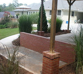 build carport over parking pad and add concrete walkway, Finished view of storage pad brick wall barrier and brick post columns
