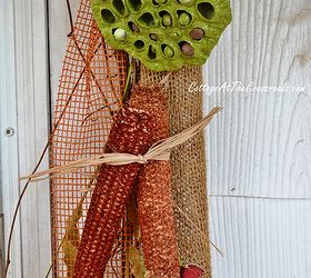 scarecrows on our fall porch, porches, seasonal holiday decor, wreaths, Corncobs and seed pods add color to a burlap and grapevine garland around the front door