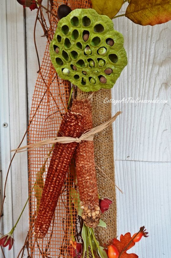 espantapjaros en nuestro porche de otoo, Las mazorcas de ma z y las vainas de semillas a aden color a una guirnalda de arpillera y vides alrededor de la puerta principal