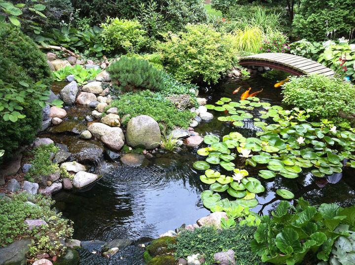 add a bridge to your pond or landscape, outdoor living, ponds water features, A wooden curved bridge provides access from the patio to the perennial garden on the other side of the pond
