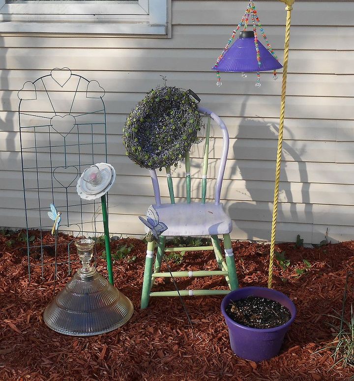 my repurposed garden, gardening, repurposing upcycling, Recycled chair and lite post with a purple plastic lamp shade into solar and a heavy glass shade on the ground with a solar lite inside along with a recycled glass blossom