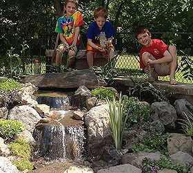 landscape garden design waterfalls water feature patio sitting wall with pillars, The entire family even the kids can now enjoy their new Outdoor Room in Brighton NY by Acorn Landscaping of Rochester NY