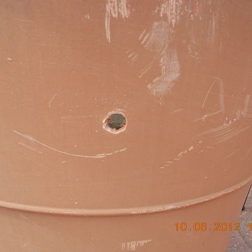umbrella holder in a cement plant container, drilled 4 holes to drain from rain