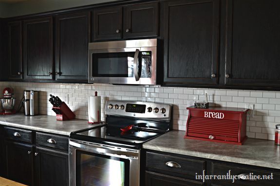 white subway tile backsplash with black cabinets