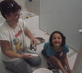 bathroom remodel, bathroom ideas, home improvement, Here I am teaching my granddaughter how to lay the bullnose baseboard tiles