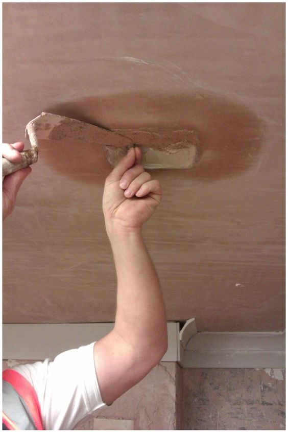 how to repair a small hole in your ceiling, Continuing to hold onto the nail and using a Thistle Bonding plaster the patch is continued to be built out level with the existing surface