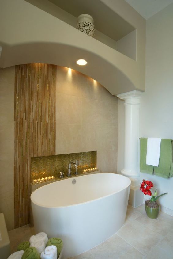 our homeowners expressed a desire to change their early 90 s inspired pink bathroom, bathroom ideas, home decor, We created the stunning waterfall effect using glass wall tile accents flowing down into the niche area as an eye catching accent making the unique limestone tub our centerpiece