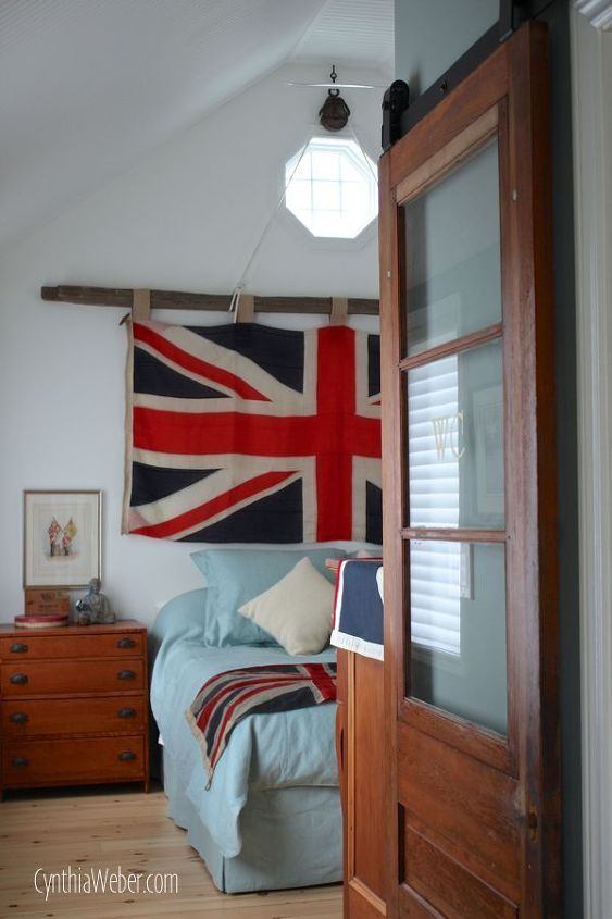 creating a rustic chic bedroom with a vintage union jack flag, bedroom ideas, home decor, A barn door track system from Rustica Hardware adds just the right touch Notice the WC on the bathroom door