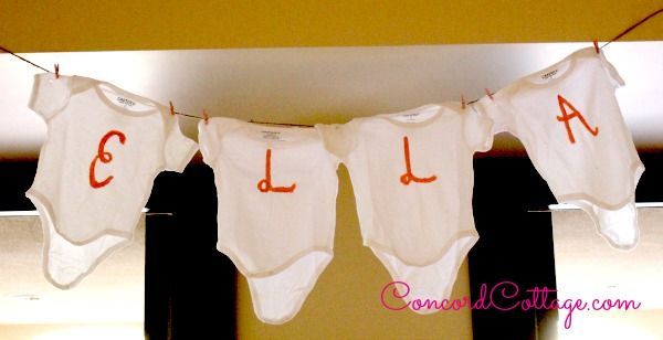 baby shower rosa, Peleles pintados a mano con las iniciales del beb y colgados en el tendedero