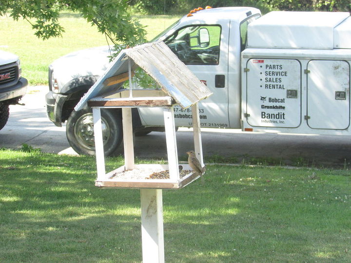 un alimentador de aves de metal oxidado utilizando materiales de desecho