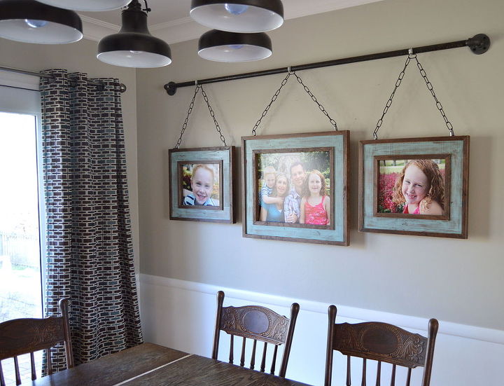 creative way to hang pictures with family photos on a curtain rod in dining room