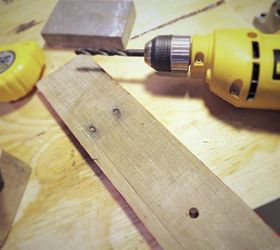 She drills a hole through a piece of pallet wood for this quick and clever decor idea