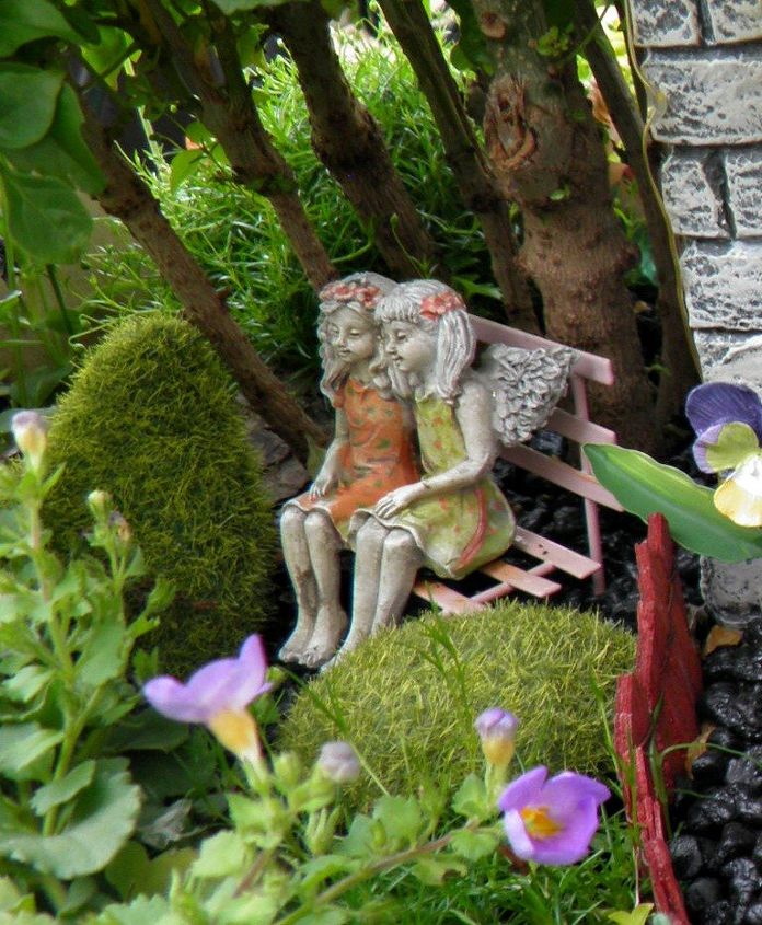 playing in the fairy garden, container gardening, gardening, Twin fairies are sitting beneath a tree