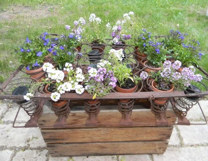 an apple box rusted out mattress springs solar lights cuteness, container gardening, flowers, gardening, repurposing upcycling, Side view during the day