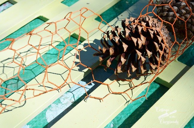 corona otonal de alambre de pollo y conos de pino