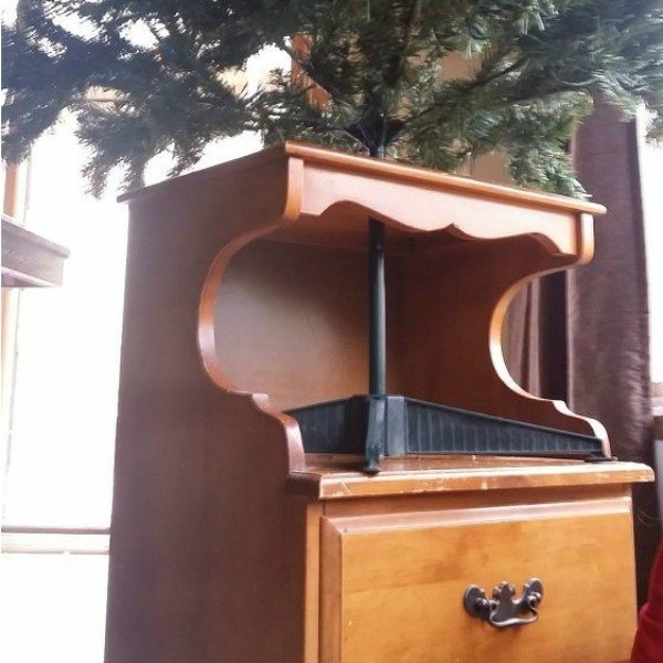 s 7 brilliant ways to protect your christmas tree from toppling, christmas decorations, seasonal holiday decor, Use an Extra Piece of Furniture to Ground It