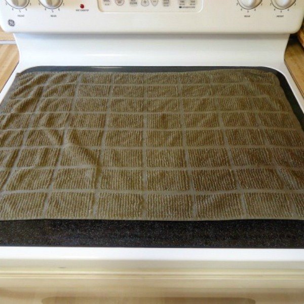 s 10 tiny changes to cut your cleaning routine in half, cleaning tips, Lay a towel on your glass stovetop