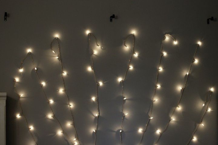 she hangs string lights above her bed and the final step hooks to hang christmas lights outside
