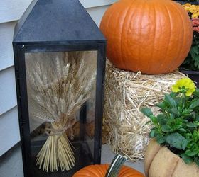 my front porch for fall pumpkins fall flowers lanterns and a fun corn garland, curb appeal, flowers, home decor, seasonal holiday decor, A lantern filled with wheat welcomes my guests