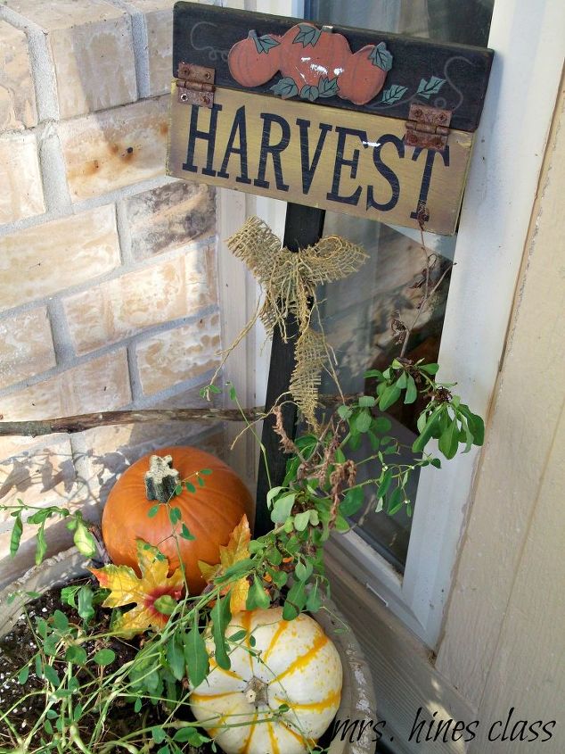 decorating the front porch for fall, home decor, seasonal holiday decor, A couple of pumpkins and a harvest yard sign take the potted plant from Summer to Fall