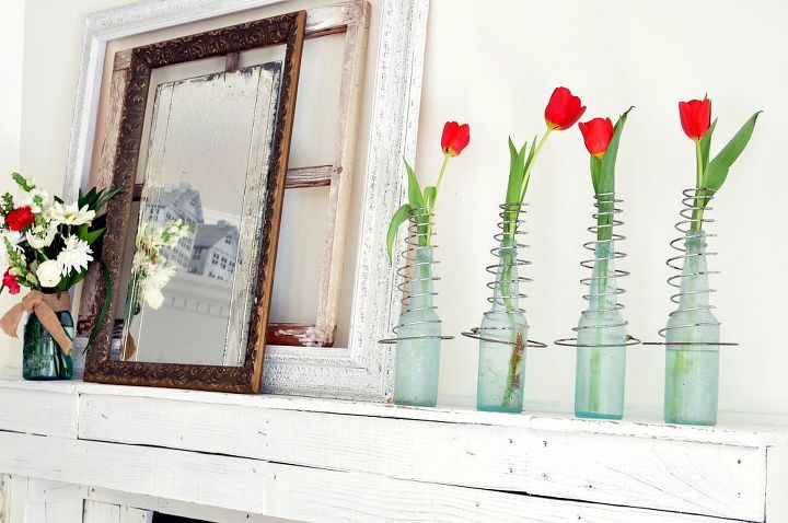 ideas para san valentn, Unos muelles de cama vintage sobre botellas viejas sostienen tulipanes rojos en la chimenea