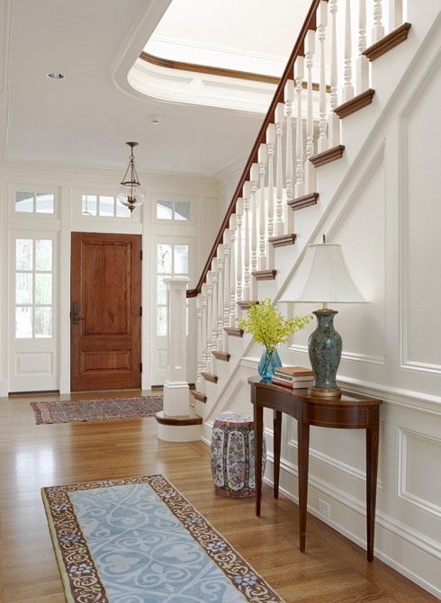 details details how you can add character and pizazz to your home, home decor, The paneling throughout this entryway is so clean and crisp painted white Love the stained wood door and railings Nice pop of color