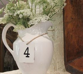 how to create a summertime mantel for free, flowers, home decor, A simple white pitcher filled to the brim with Queen Anne s Lace and a metal numbered tag