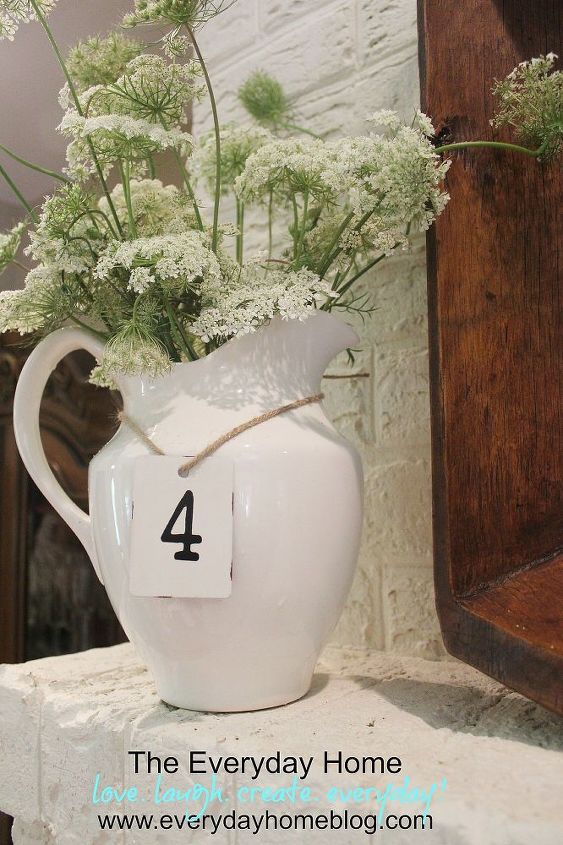 how to create a summertime mantel for free, flowers, home decor, A simple white pitcher filled to the brim with Queen Anne s Lace and a metal numbered tag
