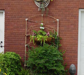 honored to host our first home garden tour this spring, flowers, gardening, outdoor living, Antique iron bed made into a trellis for our Euonymous Wintercreeper barely visible on the bottom right Soon it will be climbing all over it s new home Credit goes to someone on Hometalk for the garden hose wreath idea