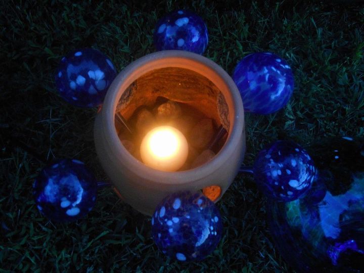 hmm a bright light went off in my brain, outdoor living, repurposing upcycling, Renove globe light the candle which sits atop rocks that hold down the long sems of the watering orbes