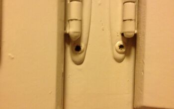  Como você remove parafusos arranhados e pintados de portas de armários antigos?