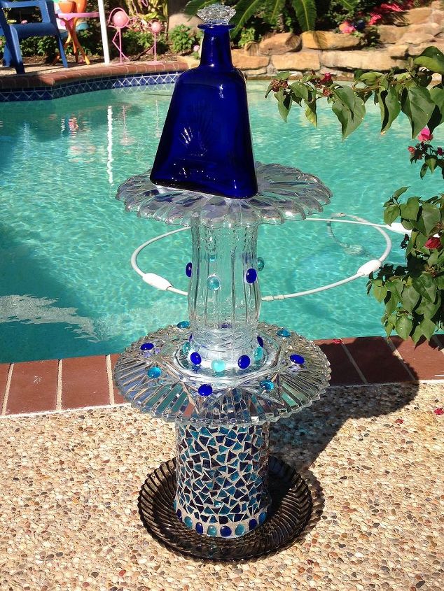 finally started making my plate flowers and glass towers what fun, My 1st glass totem I used GE Silicone but found out it does NOT dry clear so I switched to Plumbers GOOP and is clear water proof and strong Top piece looks off center but it s a triangle cobalt bottle looks straight from the front