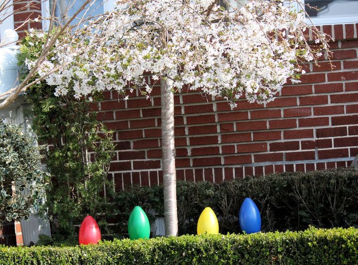 easter decoration for indoor and outdoor, easter decorations, gardening, seasonal holiday d cor, Easter eggs under blooming Springs tree It s as easy as it looks Find your nearest craft store and buy those colorful large plastic Easter eggs A selection of 3 6 is ideal when decorating an outside space like the beautiful tree seen here Locate the most desirable section in your garden and arrange accordingly