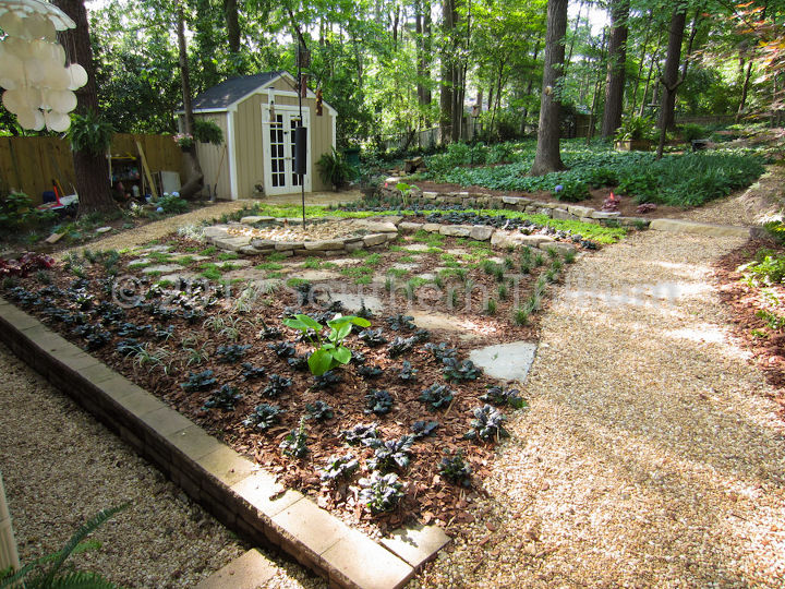 reforma de quintal para amantes de pssaros, Olhando atrav s da rea do quintal rec m instalada com os alimentadores de p ssaros servindo como ponto focal em seu jardim Paredes de pedra de campo empilhadas a seco informais criam novos n veis de terra o Em seguida usamos uma combina o de lajes e v rios tipos de plantas para criar movimento e interesse em todo o espa o