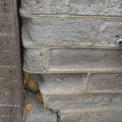 q ick que hacer con el ladrillo de esta casa, la esquina inferior derecha de la puerta principal