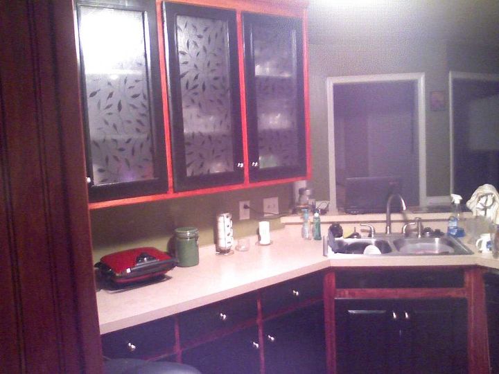 this is a kitchen cabinet refacing project we wanted to give the customer an, home decor, kitchen design, painting, After We sanded the cabinets down to the bare wood Then we stained them cherry The doors were made of pressed wood and wouldn t take stain so we painted them black and cut out the center on the top to add frosted glass