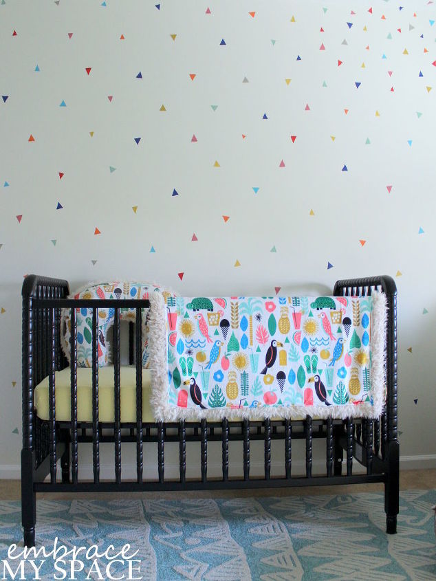 um quarto infantil branco com toques de cor e abacaxi