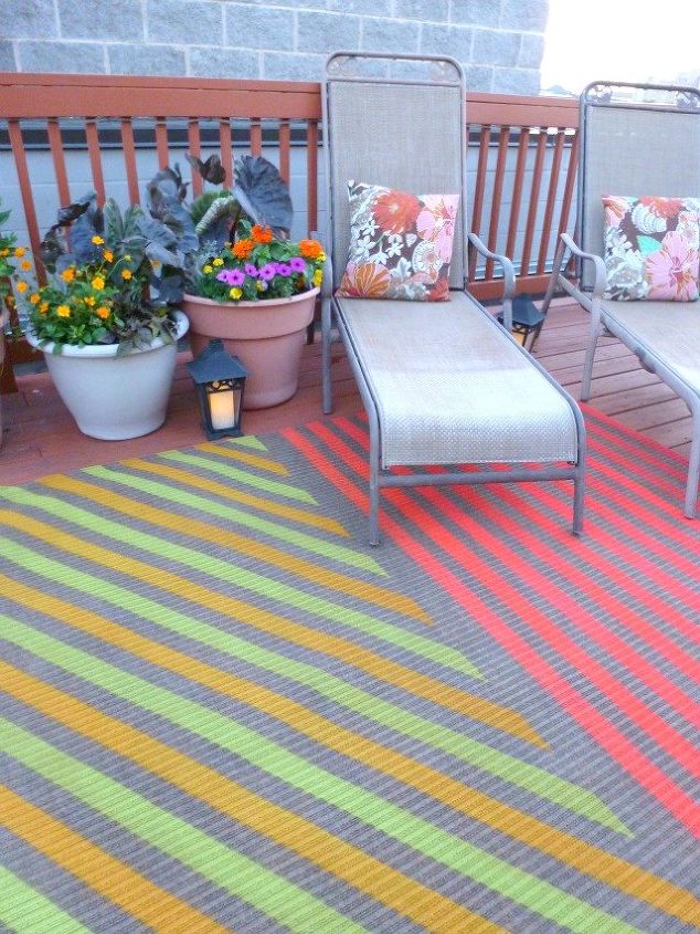 13 expensive looking outdoor rug ideas that cost less than 20, Spray paint colorful stripes over a cheap rug