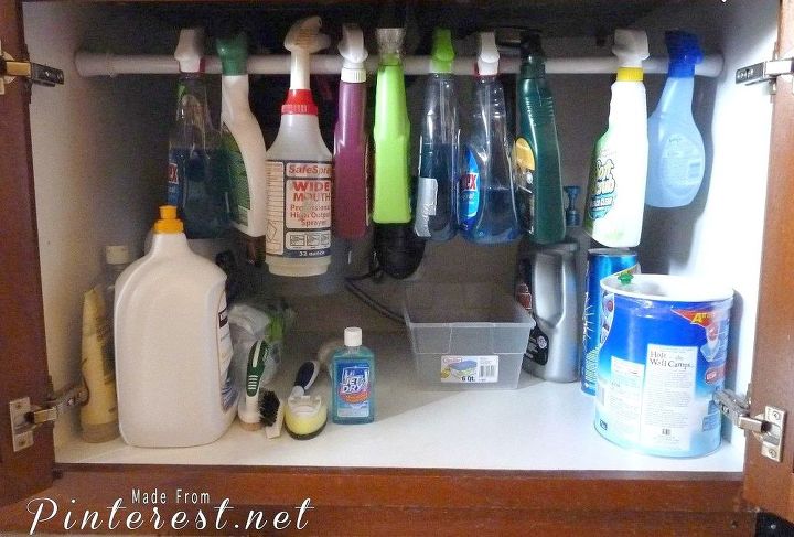 the 15 smartest storage hacks for under your sink, Hang a tension rod to hold spray bottles