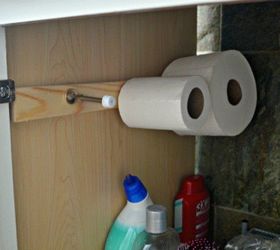the 15 smartest storage hacks for under your sink, Put door stoppers on a wall to hold TP rolls