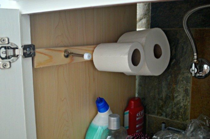 the 15 smartest storage hacks for under your sink, Put door stoppers on a wall to hold TP rolls