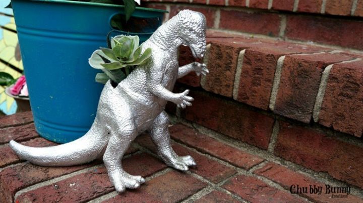 17 maneras increblemente divertidas de exhibir tus suculentas favoritas, Convierte un juguete de dinosaurio en una maceta